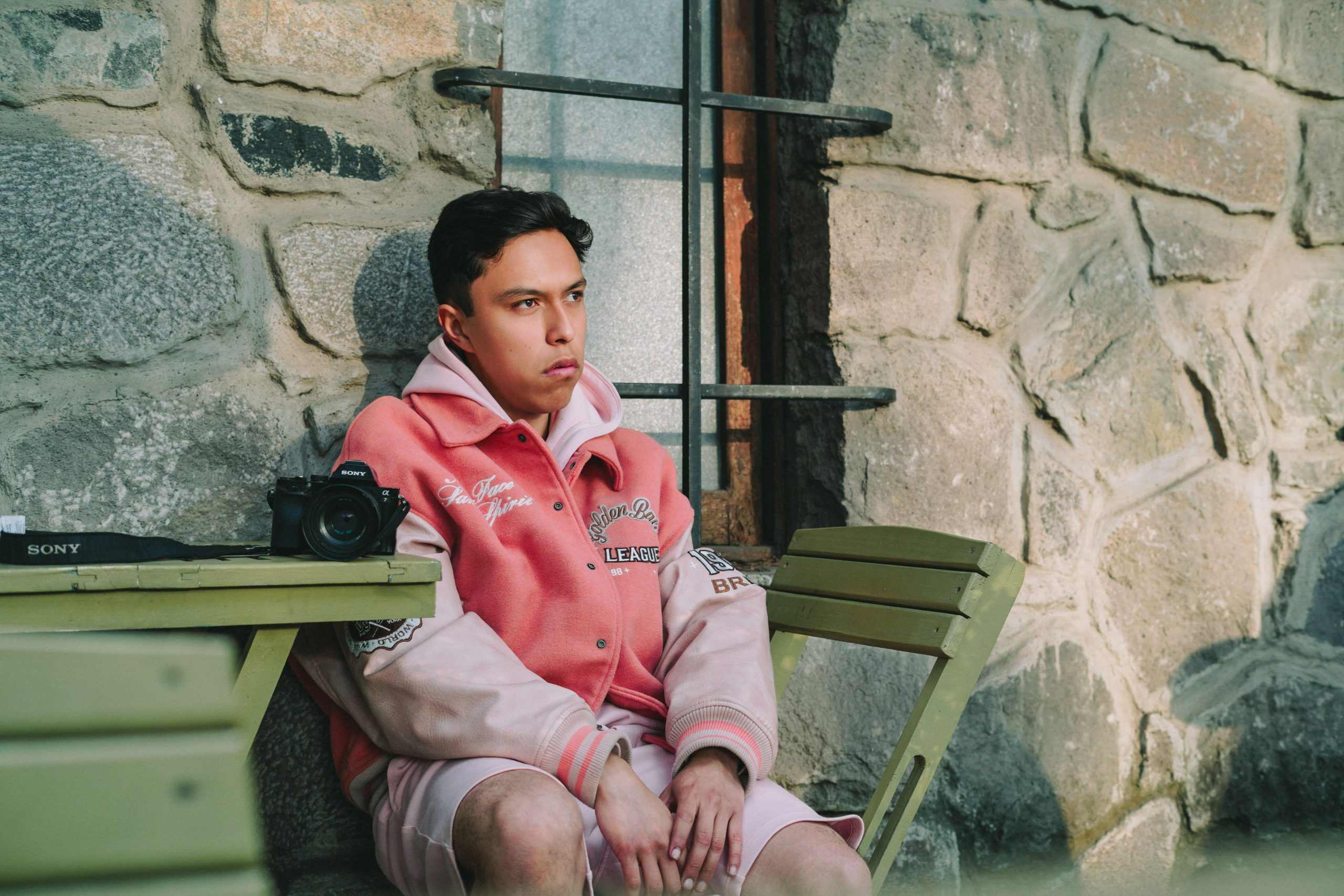 Homme en veste rose avec appareil photo.