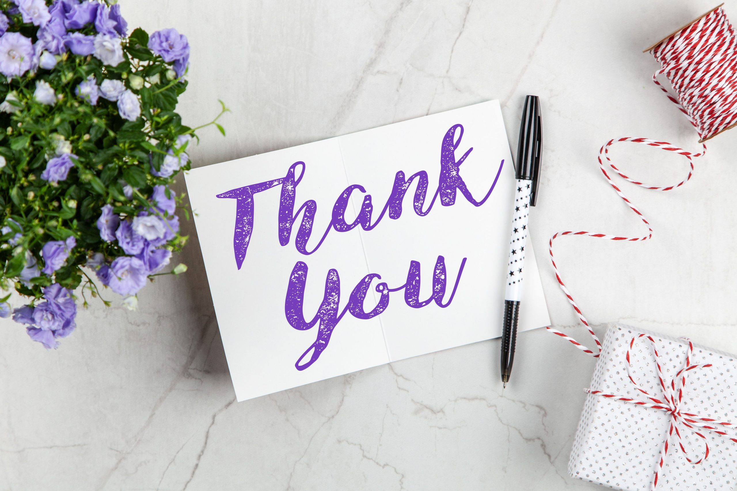 Carte merci stylisée avec fleurs violettes et cadeau