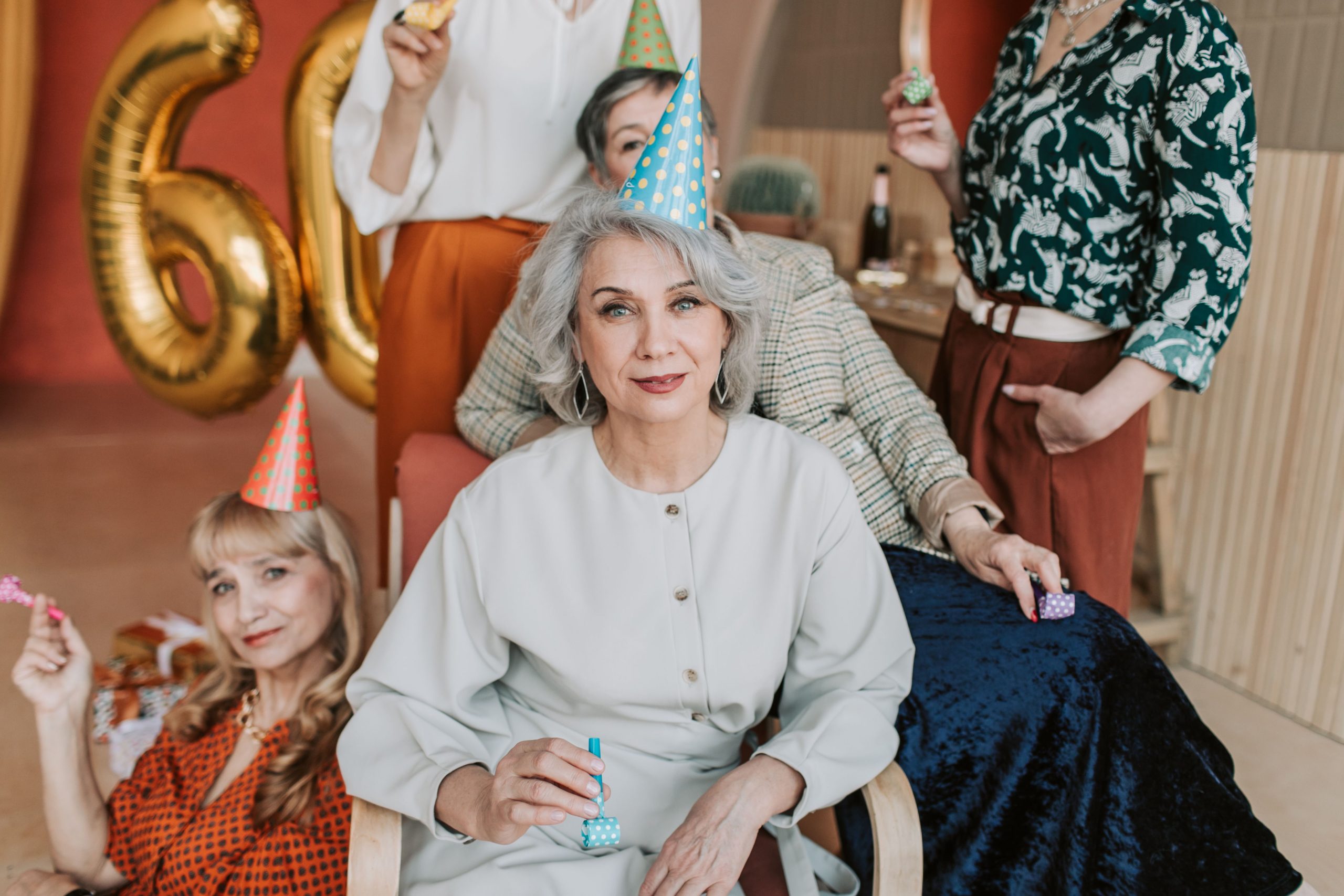 Femmes seniors célébrant 60 ans avec chapeaux fête
