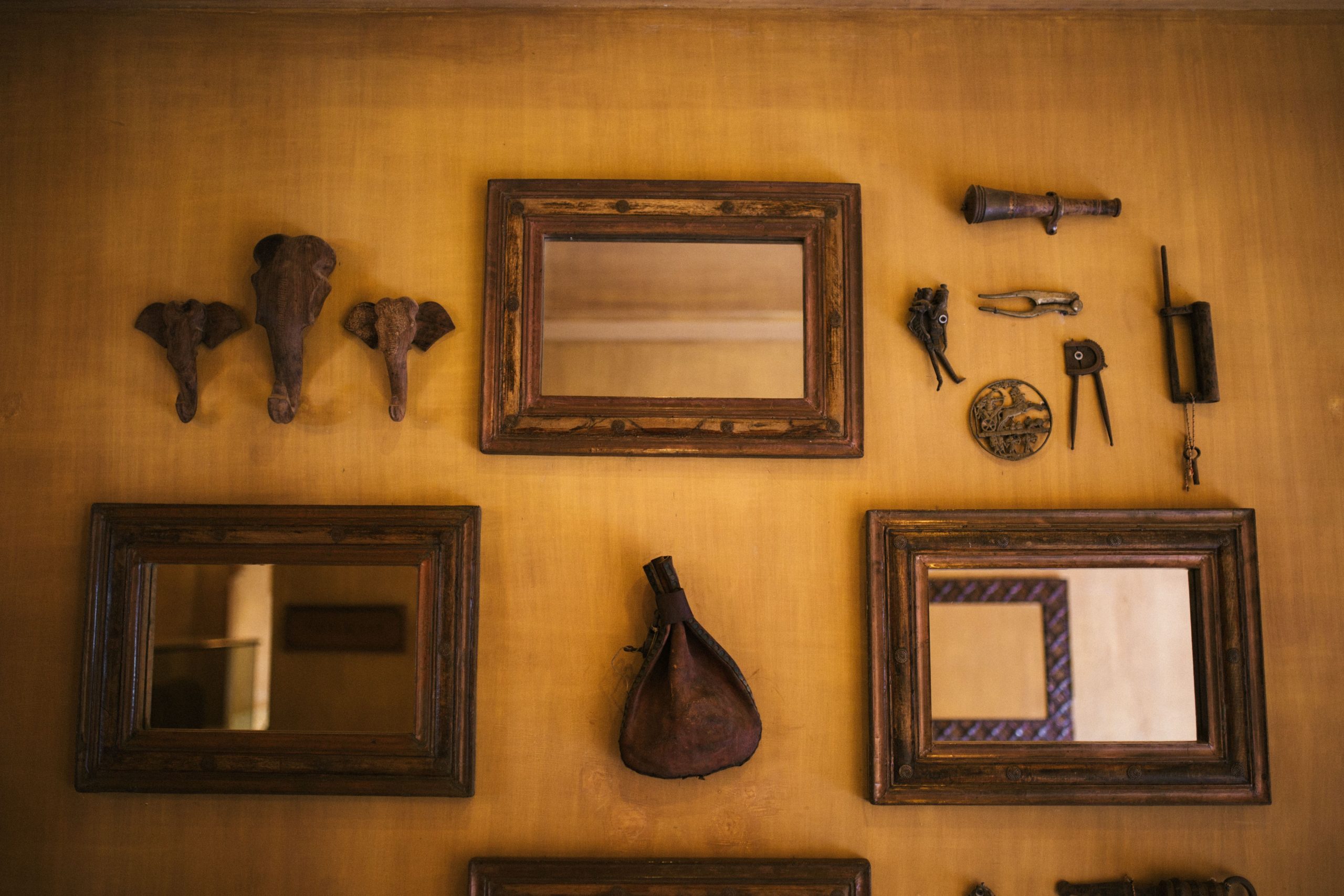 Miroirs vintage et objets sur mur rustique.