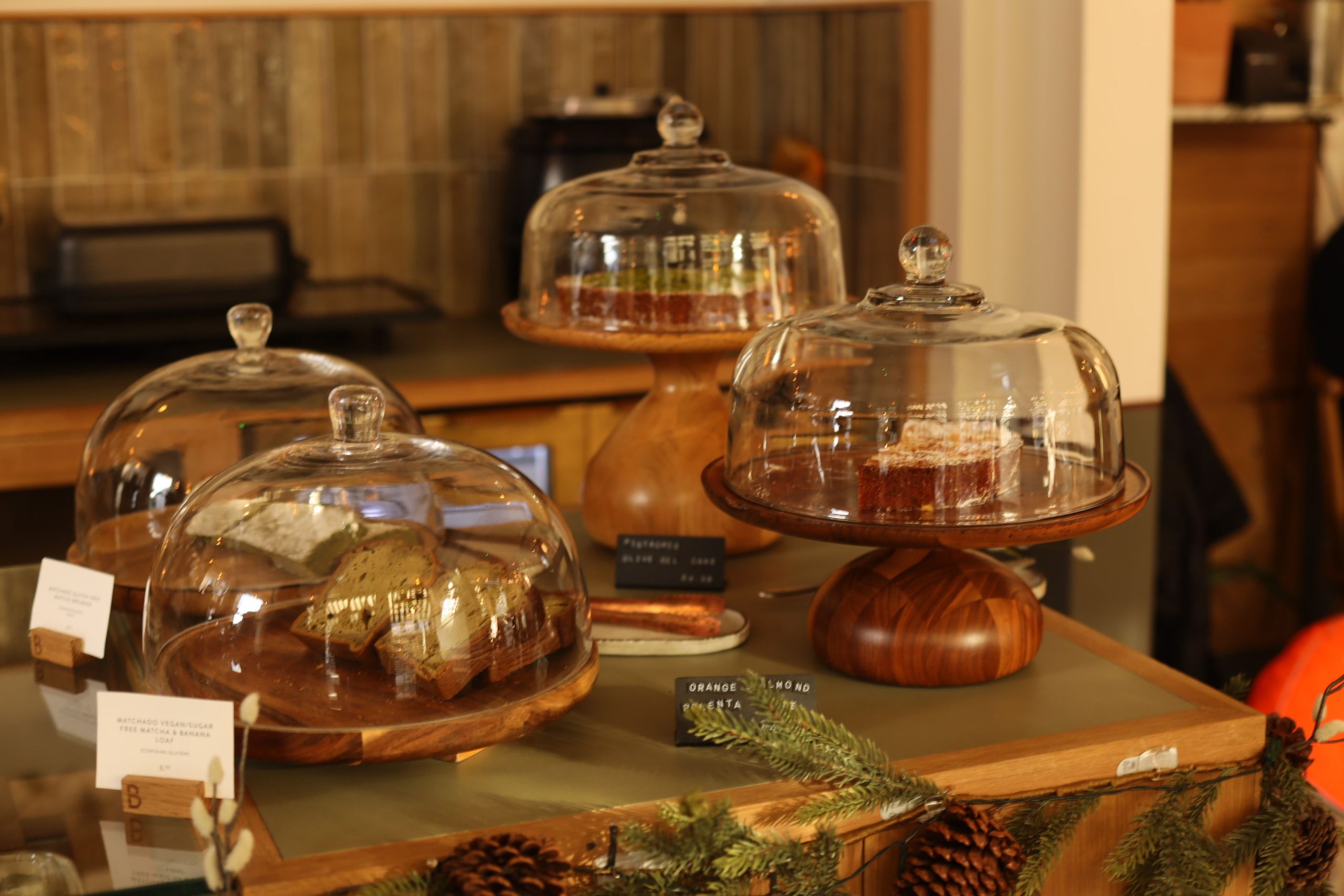Pâtisseries sous cloches de verre sur présentoirs en bois